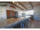 Bright kitchen with granite island, white cabinets, stainless appliances, and charming rustic ceiling beams at 10523 E Sleepy Hollow Trl, Gold Canyon, AZ 85118