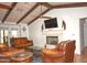Comfortable living room with fireplace, wood beams, and leather seating, perfect for relaxing or gathering at 10523 E Sleepy Hollow Trl, Gold Canyon, AZ 85118