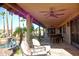 Inviting covered outdoor patio with stone flooring, comfortable seating, and scenic pool views for relaxation at 10523 E Sleepy Hollow Trl, Gold Canyon, AZ 85118