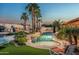 Backyard pool with palm trees, a waterfall feature, lounge chairs, and lush tropical landscaping at 10523 E Sleepy Hollow Trl, Gold Canyon, AZ 85118