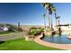 Relaxing pool area with rock features, lush landscaping, and hammock at 10523 E Sleepy Hollow Trl, Gold Canyon, AZ 85118