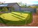 Backyard putting green with solar lights and a home with solar panels in the background at 10523 E Sleepy Hollow Trl, Gold Canyon, AZ 85118