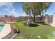 Backyard featuring an outdoor dining area and artificial turf, perfect for relaxation and recreation at 10702 W Orangewood Ave, Glendale, AZ 85307