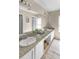 Bathroom featuring double sinks, granite counters, white cabinets, and modern lighting fixtures at 10702 W Orangewood Ave, Glendale, AZ 85307