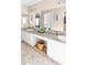 Spacious bathroom with double sinks, granite counters, white cabinets, and decorative accents at 10702 W Orangewood Ave, Glendale, AZ 85307