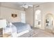 Spacious main bedroom features a ceiling fan, arched doorway, and ensuite bathroom for convenience at 10702 W Orangewood Ave, Glendale, AZ 85307