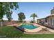 Backyard view featuring the pool, green lawn, palm tree, and an inviting outdoor space for relaxation and entertainment at 10702 W Orangewood Ave, Glendale, AZ 85307