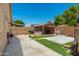 Spacious backyard featuring a covered patio area with a stone BBQ, mature trees, and a well-maintained concrete patio at 11206 W Coronado Rd, Avondale, AZ 85392