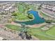Stunning aerial view of the golf course community with lush green fairways and a tranquil lake at 11550 W Mule Deer Ct, Surprise, AZ 85378