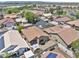 High angle of homes with tile roofs, a golf course, and solar panels at 11550 W Mule Deer Ct, Surprise, AZ 85378
