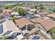 Aerial view of a residential area with multiple houses, some with solar panels, and a golf course nearby at 11550 W Mule Deer Ct, Surprise, AZ 85378