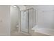 Bathroom with a glass-enclosed shower, soaking tub, and neutral tile flooring at 11550 W Mule Deer Ct, Surprise, AZ 85378