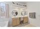 Bright bathroom with dual sinks, a vanity area, a soaking tub, and a window at 11550 W Mule Deer Ct, Surprise, AZ 85378
