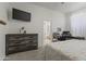 Bedroom showcasing a dresser, workspace, doorway to bathroom, and bed at 11550 W Mule Deer Ct, Surprise, AZ 85378