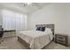 Comfortable bedroom includes a bed, nightstand, desk, and large window with natural light at 11550 W Mule Deer Ct, Surprise, AZ 85378