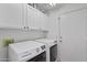 Efficient laundry room featuring a modern washer and dryer set with ample storage space at 11550 W Mule Deer Ct, Surprise, AZ 85378