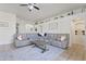 Inviting living room with a large sectional sofa, stylish rug, and tasteful decor at 11550 W Mule Deer Ct, Surprise, AZ 85378
