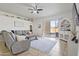 Bright living room features a comfortable sofa, ceiling fan, and sliding glass doors to the patio at 11550 W Mule Deer Ct, Surprise, AZ 85378