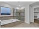 Bathroom featuring a soaking tub, glass-enclosed shower, and elegant tile work, creating a spa-like experience at 11717 W Red Hawk Dr, Peoria, AZ 85383