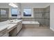 Elegant bathroom showcases a soaking tub, glass-enclosed shower, double vanity, and abundant natural light at 11717 W Red Hawk Dr, Peoria, AZ 85383