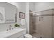 Modern bathroom showcasing a glass-enclosed shower, updated fixtures, and a sleek vanity with a framed mirror at 11717 W Red Hawk Dr, Peoria, AZ 85383