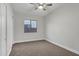 Neutral bedroom featuring a ceiling fan, cozy carpet, a window view, and closet with modern doors at 11717 W Red Hawk Dr, Peoria, AZ 85383