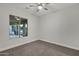 Light-filled bedroom with a ceiling fan, plush carpet, and a window view at 11717 W Red Hawk Dr, Peoria, AZ 85383