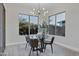Bright dining area features a glass table set and modern lighting fixture with large windows and outside view at 11717 W Red Hawk Dr, Peoria, AZ 85383