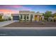 Contemporary home with desert landscaping, a gray garage door, and an inviting entryway is showcased at twilight at 11717 W Red Hawk Dr, Peoria, AZ 85383