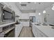 Modern kitchen with stainless steel appliances, white cabinetry, large island, and wood-look tile flooring at 11717 W Red Hawk Dr, Peoria, AZ 85383