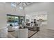 Open-concept living room flows seamlessly into the kitchen, featuring high ceilings, a fireplace, and modern decor at 11717 W Red Hawk Dr, Peoria, AZ 85383