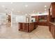 Open-concept kitchen with a large island, custom wood cabinets, and tile flooring at 1216 E Rocky Slope Dr, Phoenix, AZ 85048