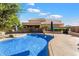 Sparkling pool with a curved design, surrounded by a patio and lush landscaping, adjacent to home at 1216 E Rocky Slope Dr, Phoenix, AZ 85048