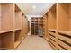 Large walk-in closet with custom built-in wood shelving and drawers for ample storage at 1216 E Rocky Slope Dr, Phoenix, AZ 85048