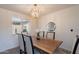 Open dining room area with modern chandelier, wood table, and views into the bright living space at 1466 E Nielson Ave, Mesa, AZ 85204