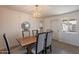 Open dining room area with modern chandelier, wood table, and views into the bright living space at 1466 E Nielson Ave, Mesa, AZ 85204