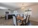 Open dining room area with modern chandelier, wood table, and views into the bright living space at 1466 E Nielson Ave, Mesa, AZ 85204