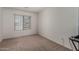 A bright bedroom featuring neutral carpet and a large window with blinds at 14936 W Maui Ln, Surprise, AZ 85379