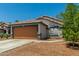 Single-story home featuring a two-car garage, desert landscaping, and a cozy exterior at 14936 W Maui Ln, Surprise, AZ 85379