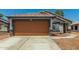 Charming single-story home showcasing a two-car garage and well-maintained desert landscaping at 14936 W Maui Ln, Surprise, AZ 85379