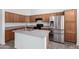 Spacious kitchen features an island, wood cabinets, and stainless appliances at 14936 W Maui Ln, Surprise, AZ 85379