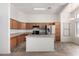 Kitchen with wood cabinets, island and stainless steel refrigerator at 14936 W Maui Ln, Surprise, AZ 85379
