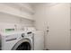 This laundry room is equipped with a washer, dryer, and shelving for convenient laundry tasks and storage at 14936 W Maui Ln, Surprise, AZ 85379