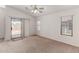 Bright, carpeted living room with sliding glass doors leading to the outdoors and two large windows at 14936 W Maui Ln, Surprise, AZ 85379