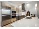Modern kitchen featuring stainless steel appliances, light wood cabinets, and a large quartz countertop at 15215 N Kierland Blvd # 101, Scottsdale, AZ 85254