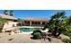 Inviting backyard pool with beautiful landscaping, covered patio, and sunny skies at 15728 W Verde Ln, Goodyear, AZ 85395