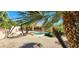 Lush backyard featuring a swimming pool, mature landscaping, and desert flora at 15728 W Verde Ln, Goodyear, AZ 85395