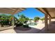 Inviting backyard pool with beautiful landscaping, covered patio, and sunny skies at 15728 W Verde Ln, Goodyear, AZ 85395