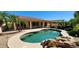 Backyard pool with rock detail and lush tropical plants at 15728 W Verde Ln, Goodyear, AZ 85395