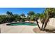 Lush backyard pool with rock waterfall feature and mature palm trees at 15728 W Verde Ln, Goodyear, AZ 85395